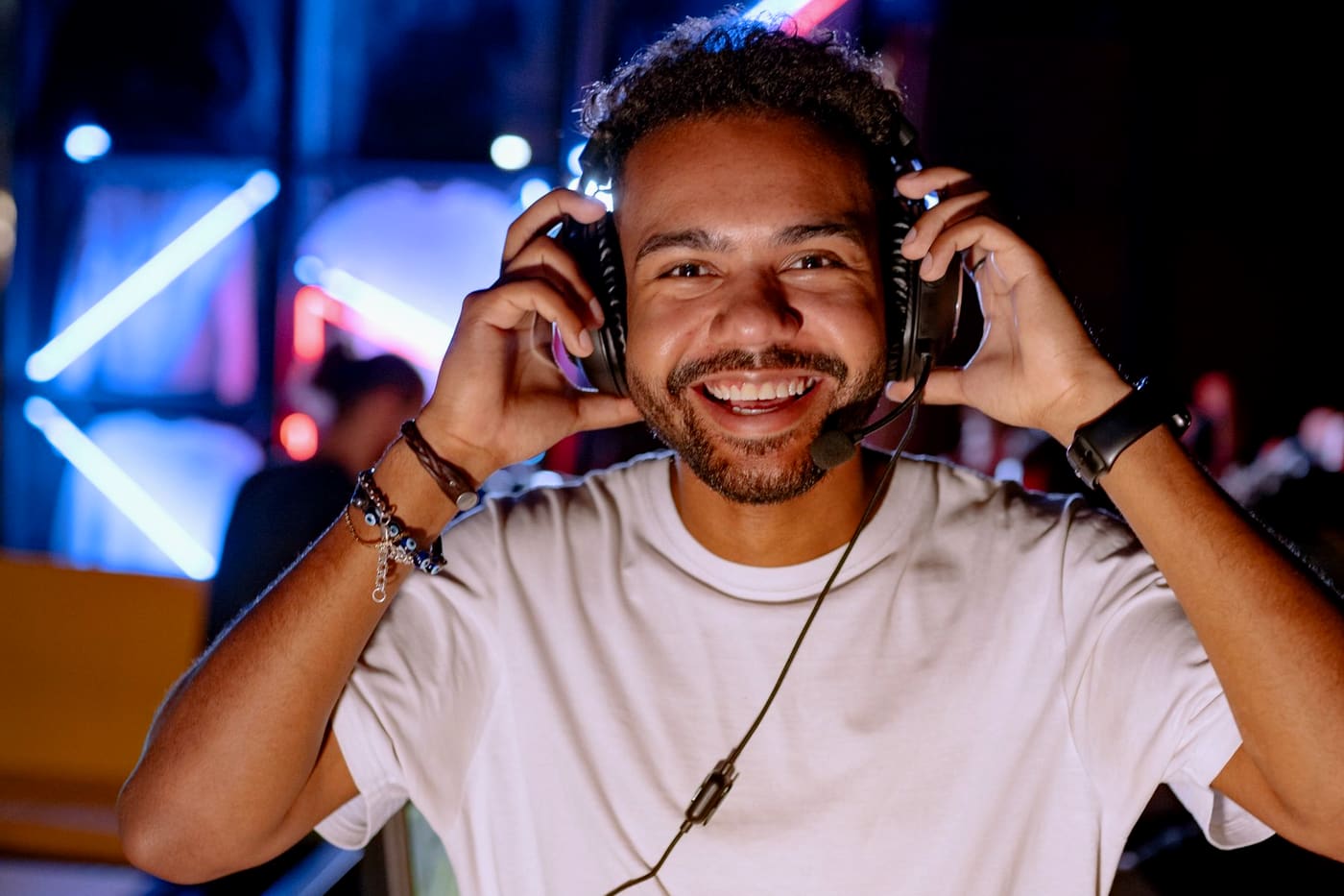 A confident adult gamer wearing a headset at a gaming station