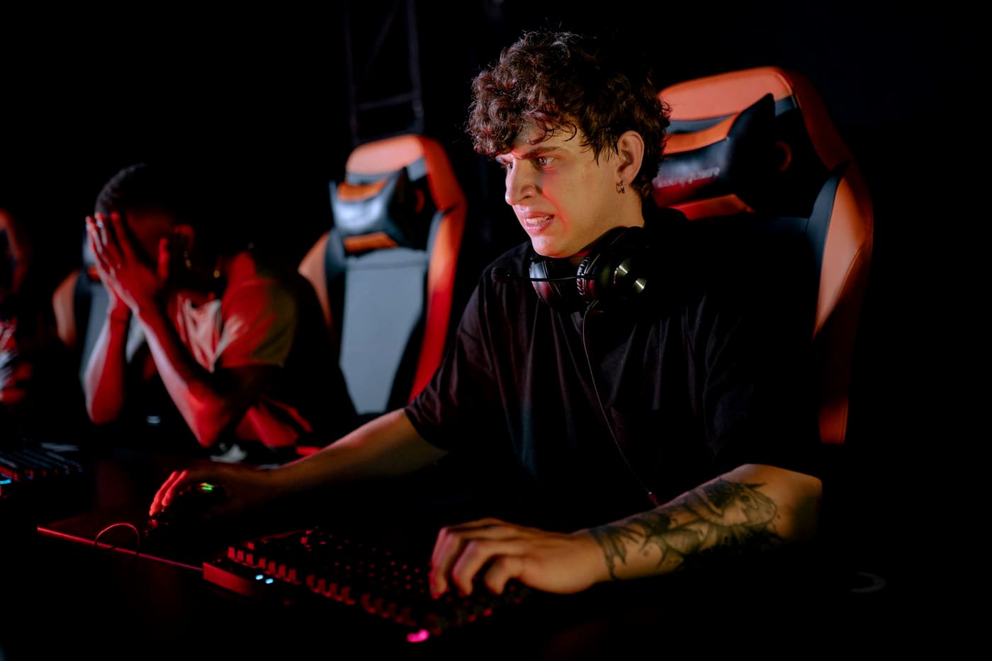 Two players at a gaming station working through gameplay together