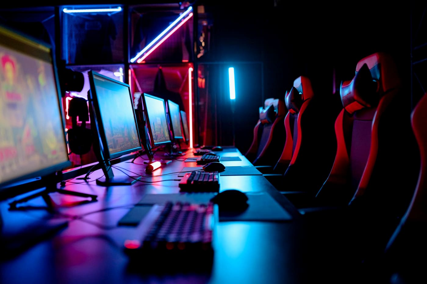 A row of gaming stations lit in blue and magenta