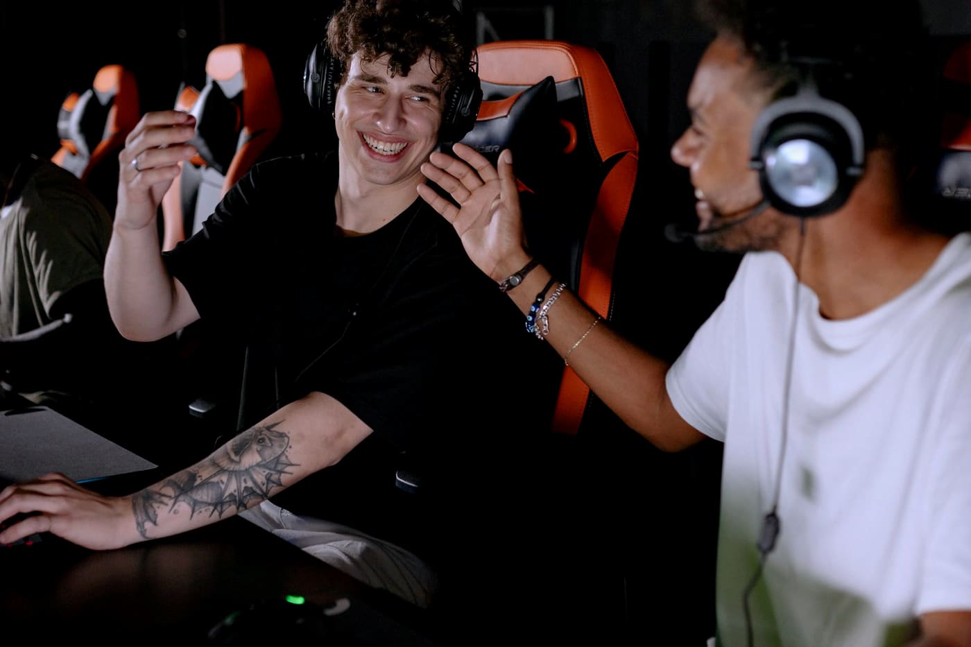Two players talking through strategy at a gaming station